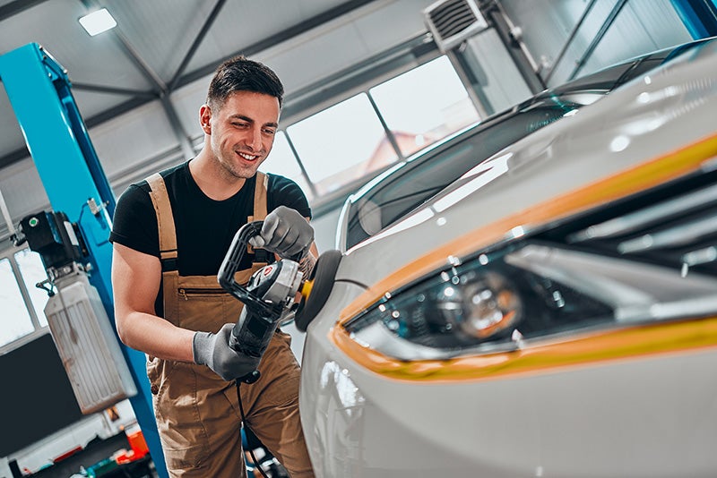 Technician servicing a car using a rolling machine