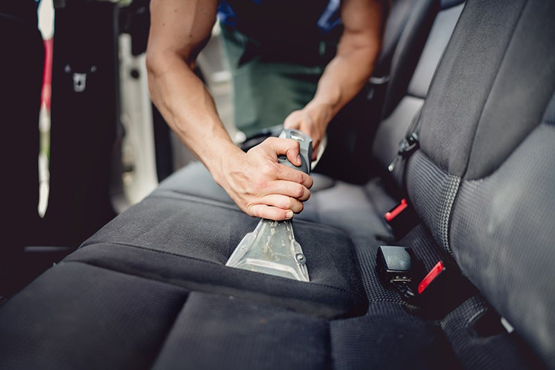 Technician servicing car seats with professional tools