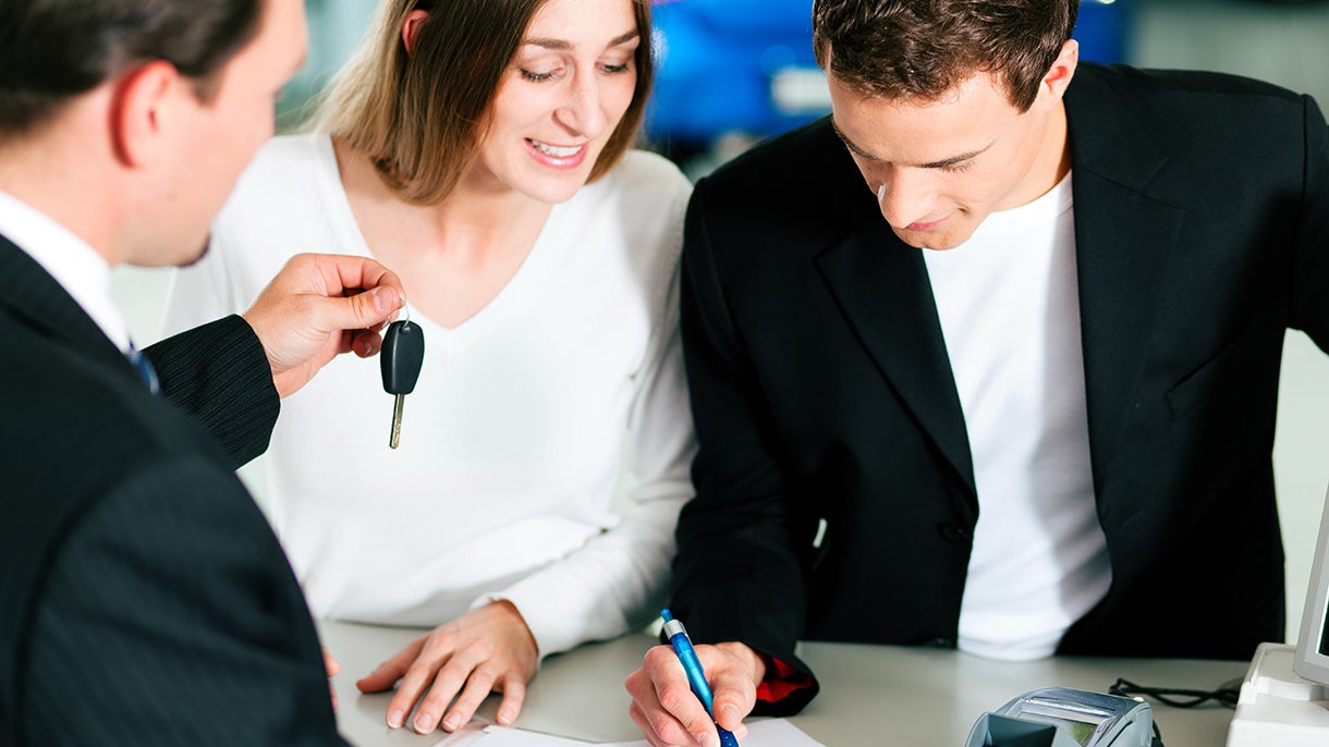 Salesman handing keys to a joyful couple
