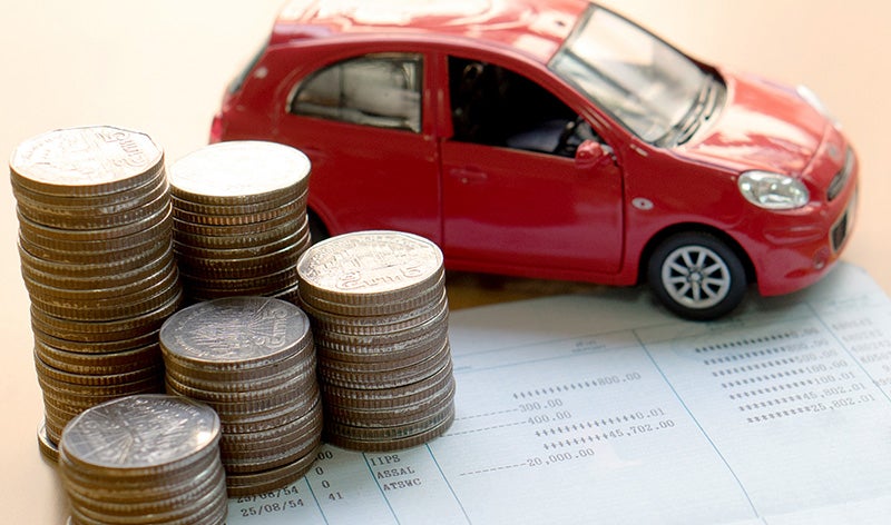 Coins, documents, and a car model on a table.