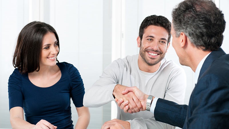 service professional greeting a Happy couple with handshake