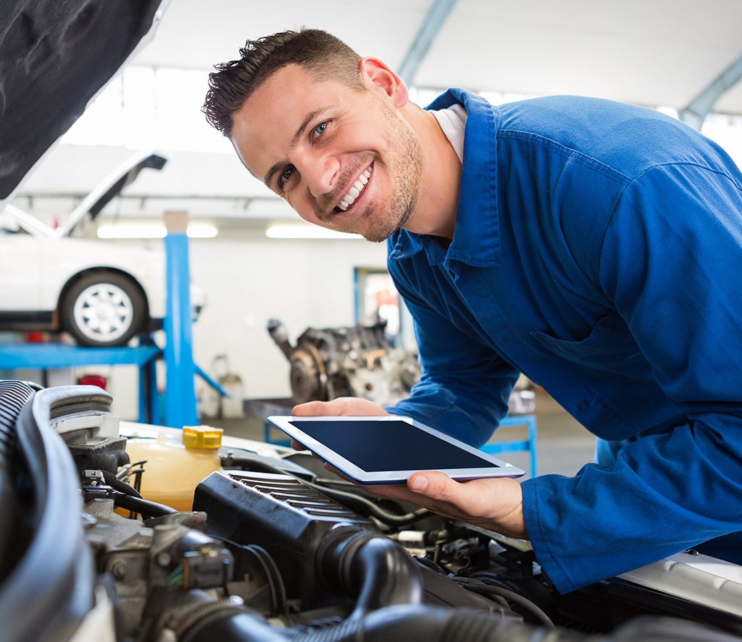 Technician servicing car with smiley face