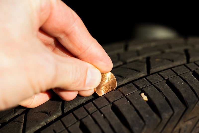 Person inserting a coin into car panel gap